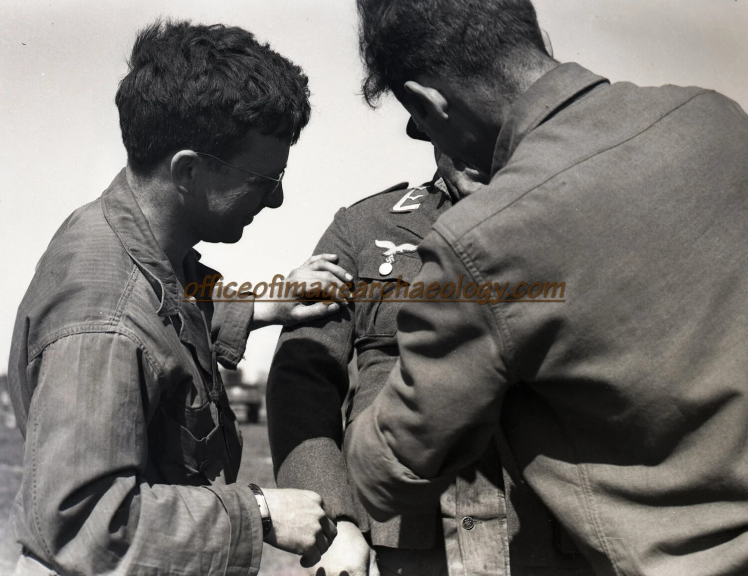 American Servicemen Inspecting Uniform Insignia of Captured Luftwaffe Airman, WWII Germany
