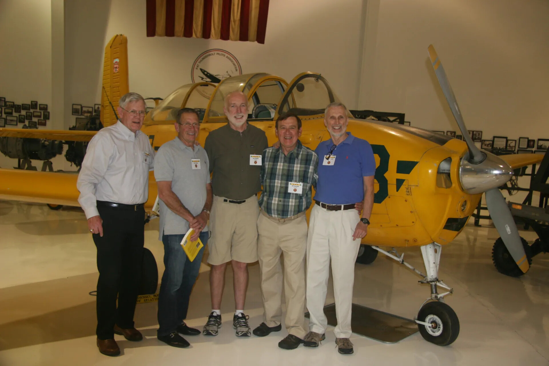 Five Veterans Posing with Vintage Training Aircraft at Aviation Museum, 2016