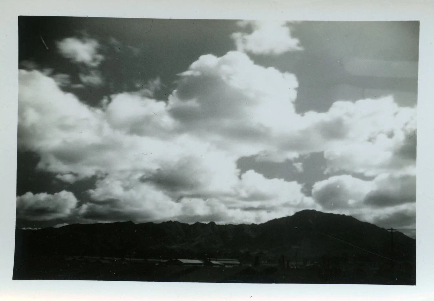 Cloud Formation Over Mountain Ridge with Base Buildings Below (Personal Snapshot)
