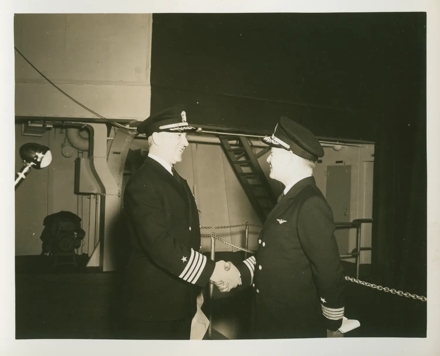 Two U.S. Navy Commanders Shaking Hands Aboard USS Petrof Bay (CVE-80)
