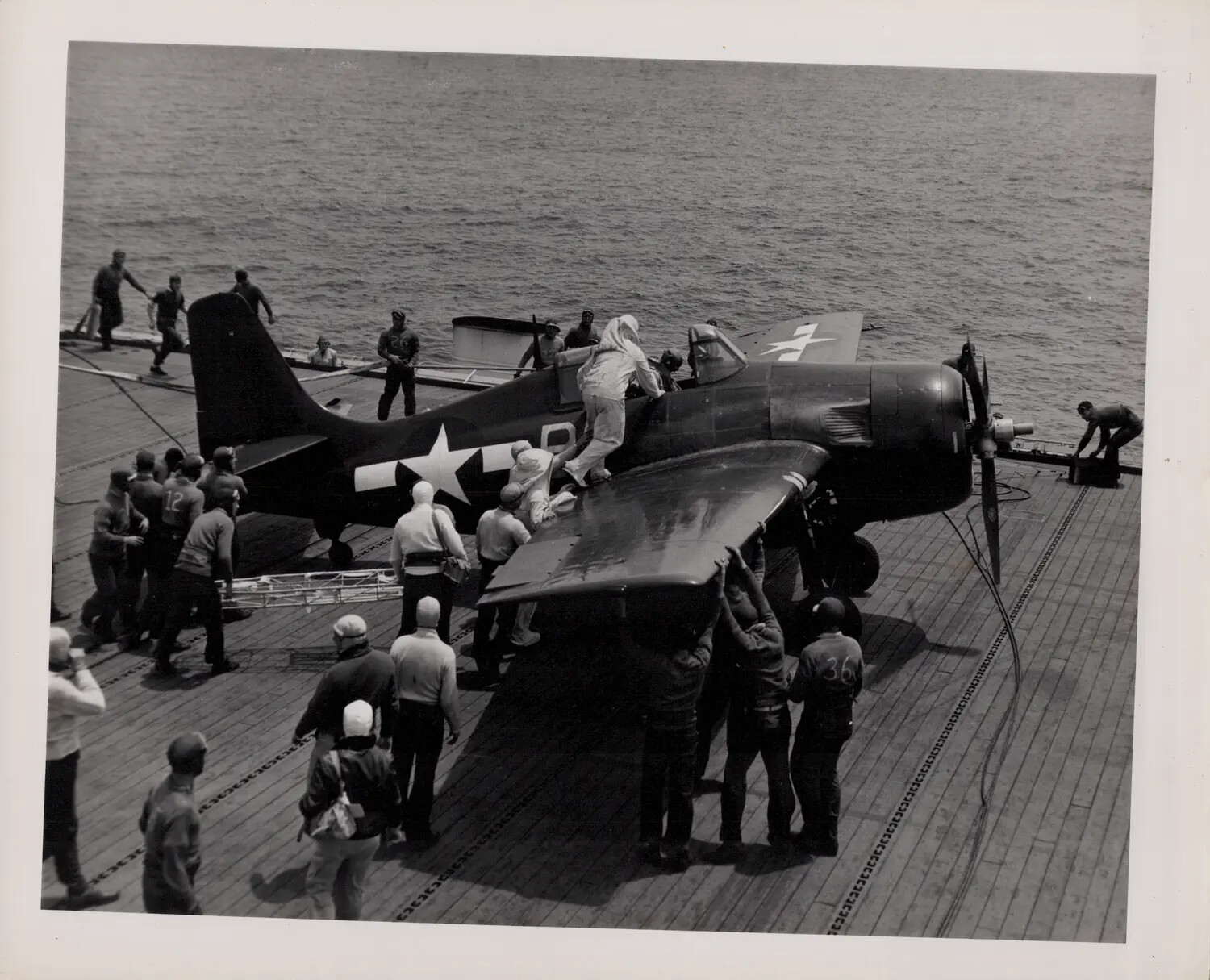 Deck Crew Handling a Grumman F6F Hellcat Aboard a US Navy Carrier, WWII Pacific