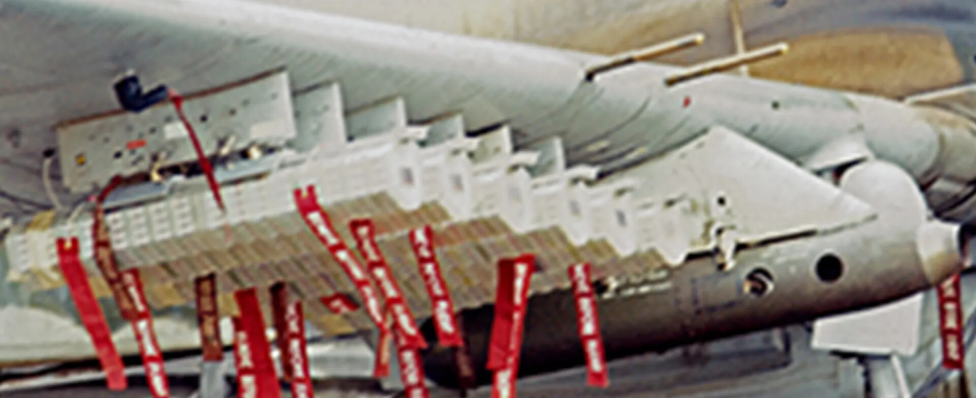Extreme Upscaled Crop of Aircraft Ordnance Racks with REMOVE BEFORE FLIGHT Streamers — Banner Project Discard File
