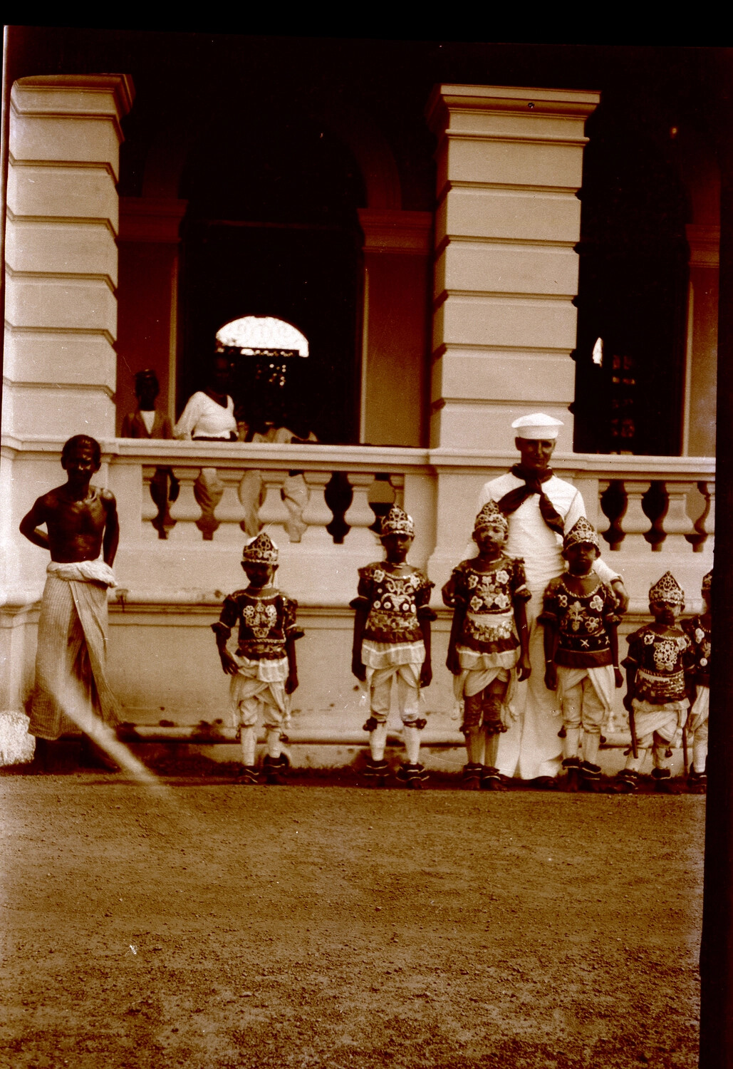 U.S. Navy Sailor with Costumed Children at a Colonial-Era Building, Likely Ceylon, 1930s