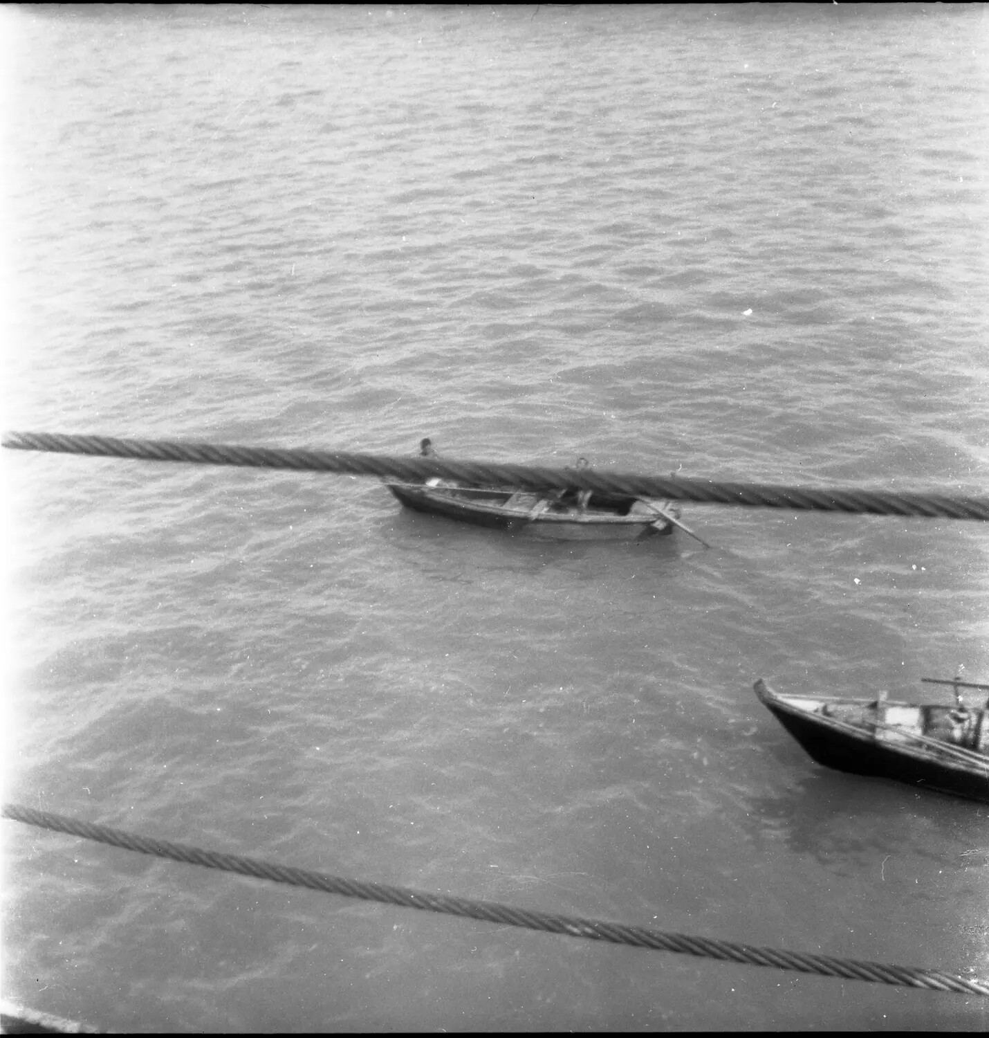 Small Craft in Sasebo Harbor, Japan, Viewed Past Ship's Mooring Cables (WWII/Occupation Era Negative)