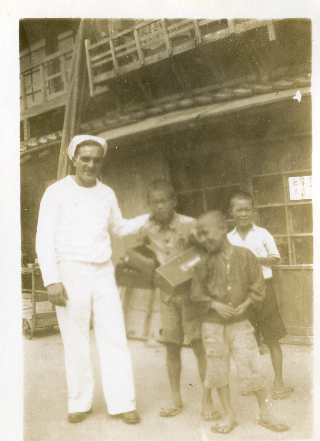 US Navy Sailor with Japanese Boys Outside Shopfront, Occupied Japan, circa 1945-1946