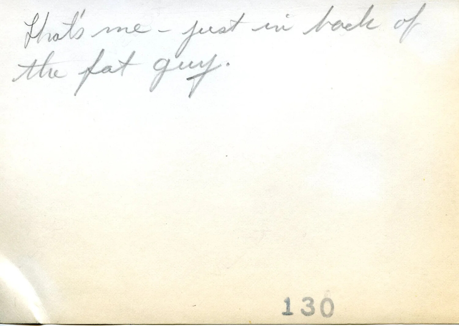 Verso of Photograph with Handwritten Caption 'That's Me - Just in Back of the Fat Guy'