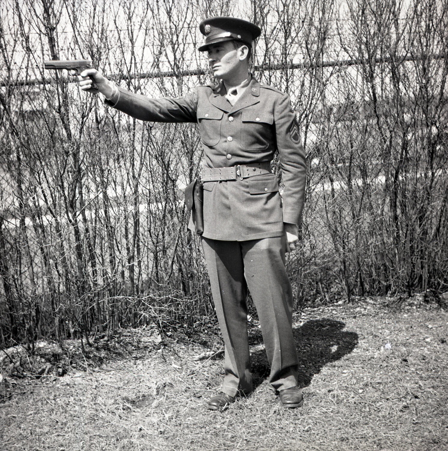 Serviceman Demonstrating Pistol Firing Stance in Dress Uniform