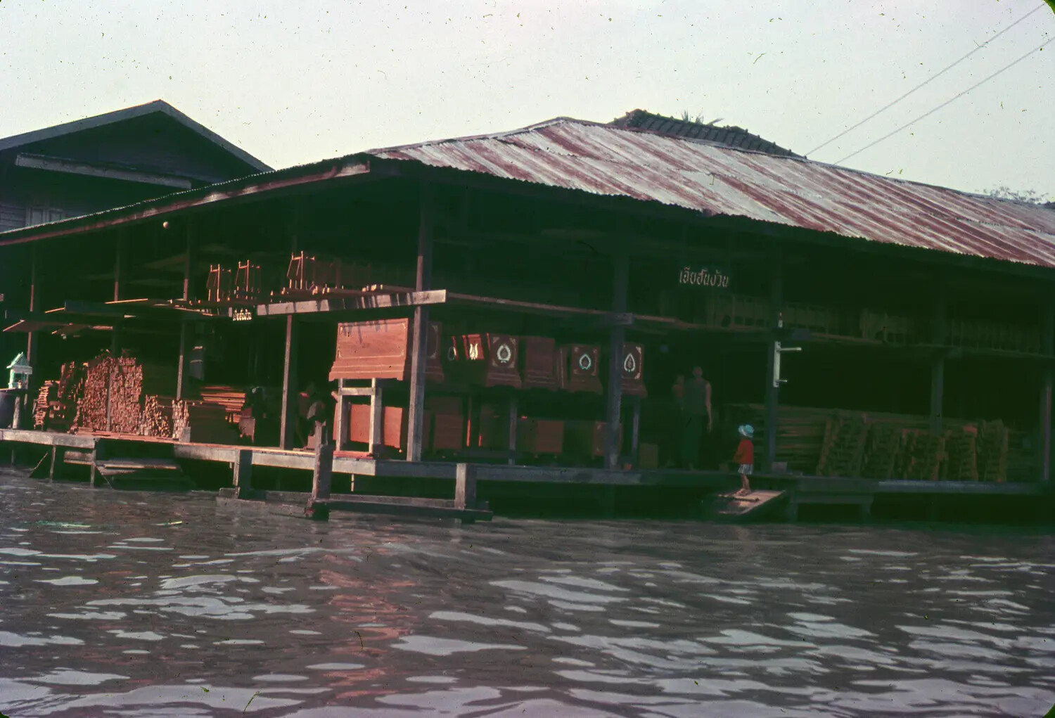 Riverside Wooden Shophouse with Thai Signage, Southeast Asia, 1965