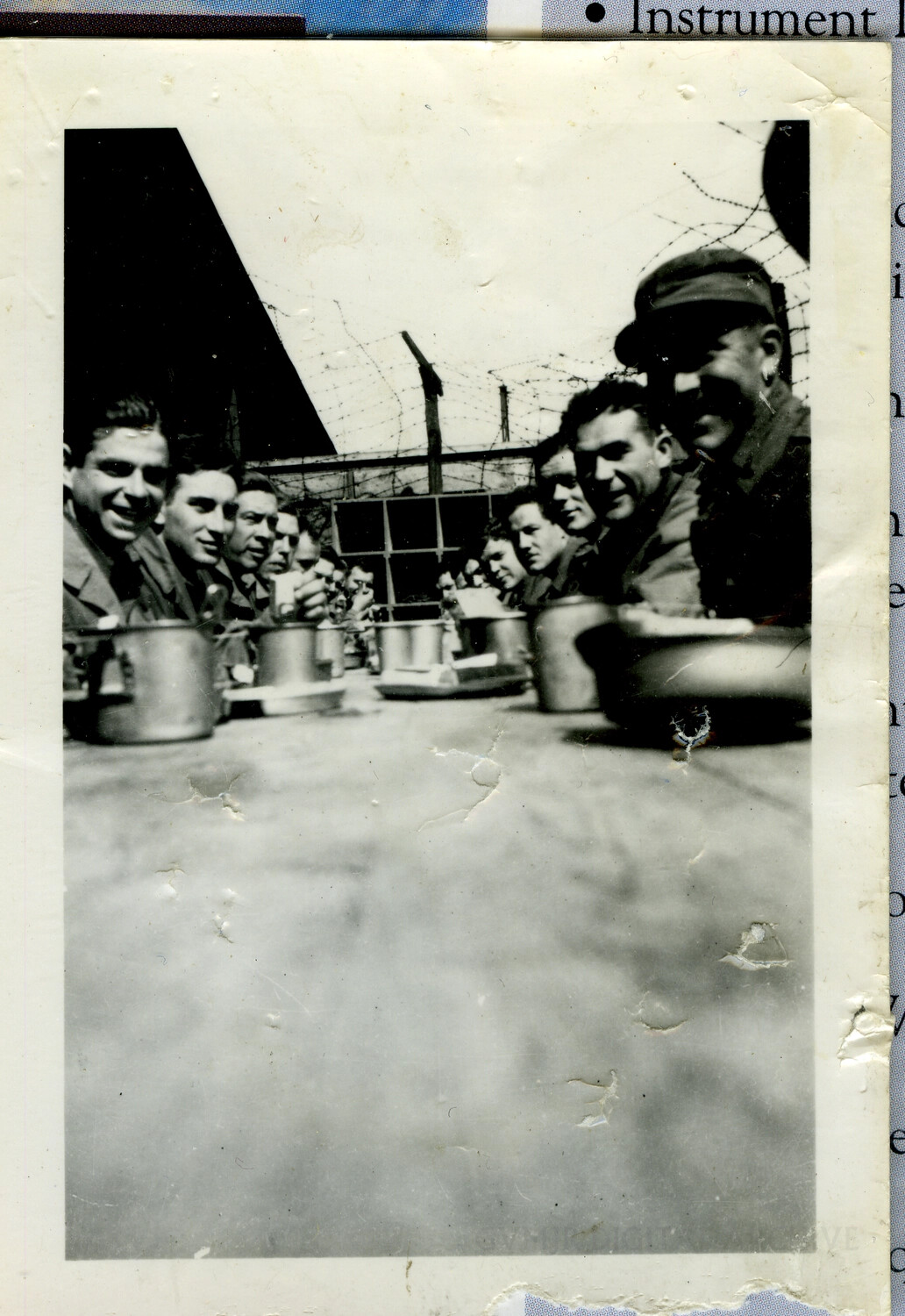 Group of Soldiers Sharing a Meal Near Barbed Wire Perimeter, European Theater, World War II