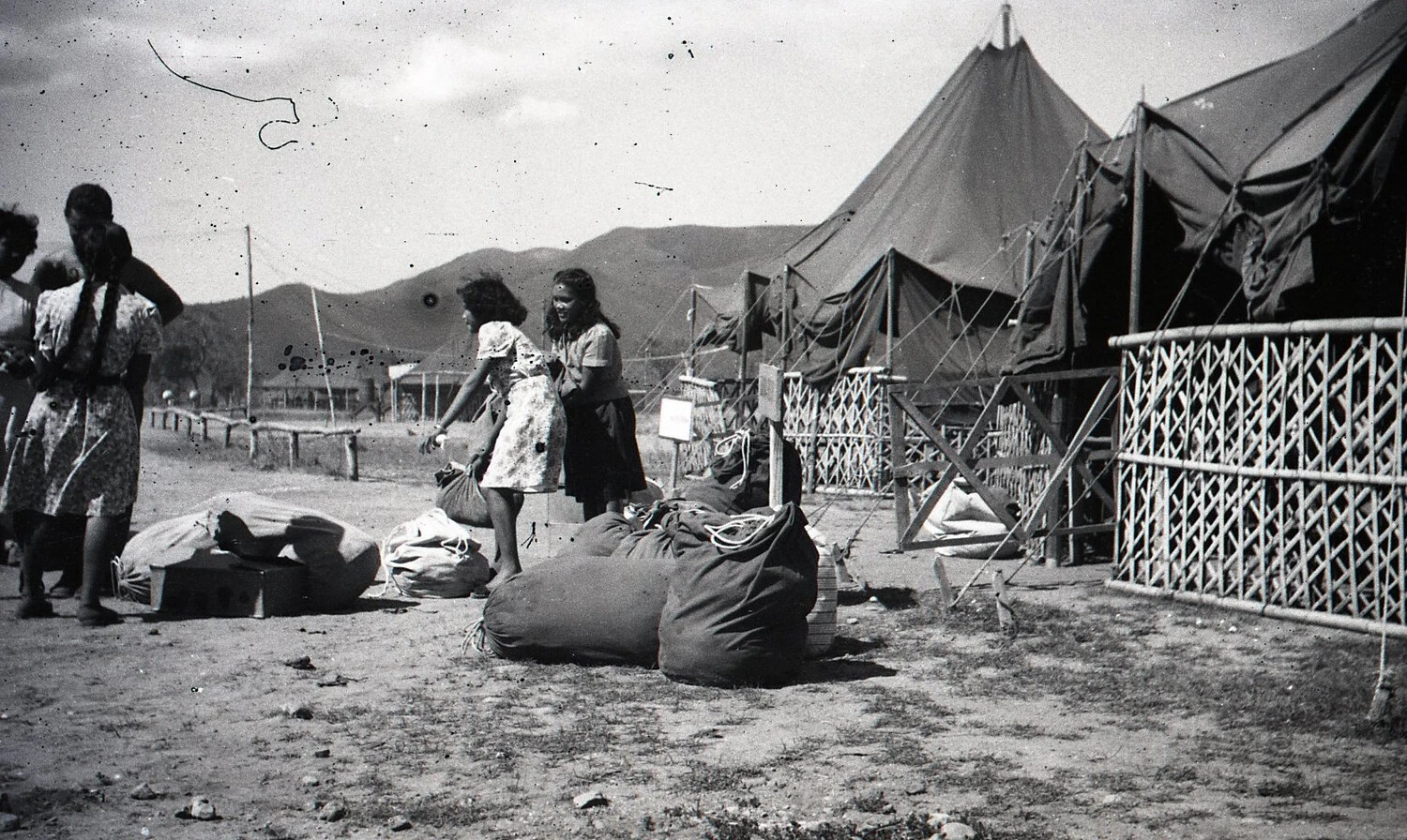 Filipino Civilians with Belongings Near Military Tent Camp, Luzon, Philippines, WWII