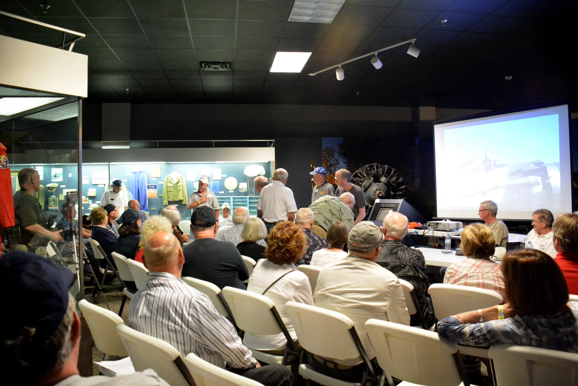 Veterans' Reunion Meeting, Aviation Museum — Informal Discussion Near Display Case