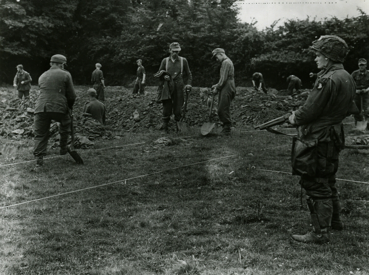 American Paratrooper Guards German POWs Digging Graves, Normandy, France, 1944