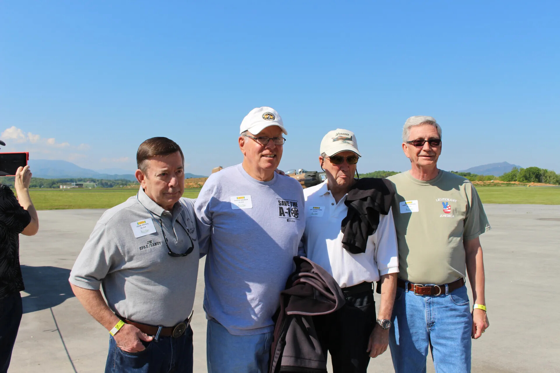 Four Veterans Posing on Ramp with Skyraider Reunion Shirts and Name Badges, 2 May 2015
