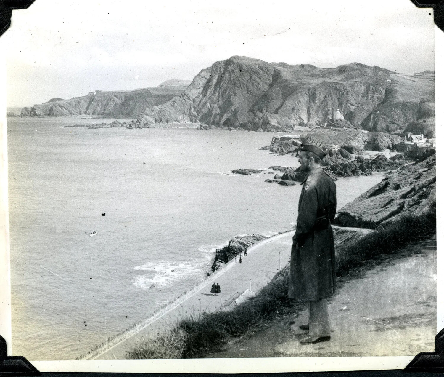 Serviceman Overlooking a Rocky Coastal Bay, Likely United Kingdom, WWII Era