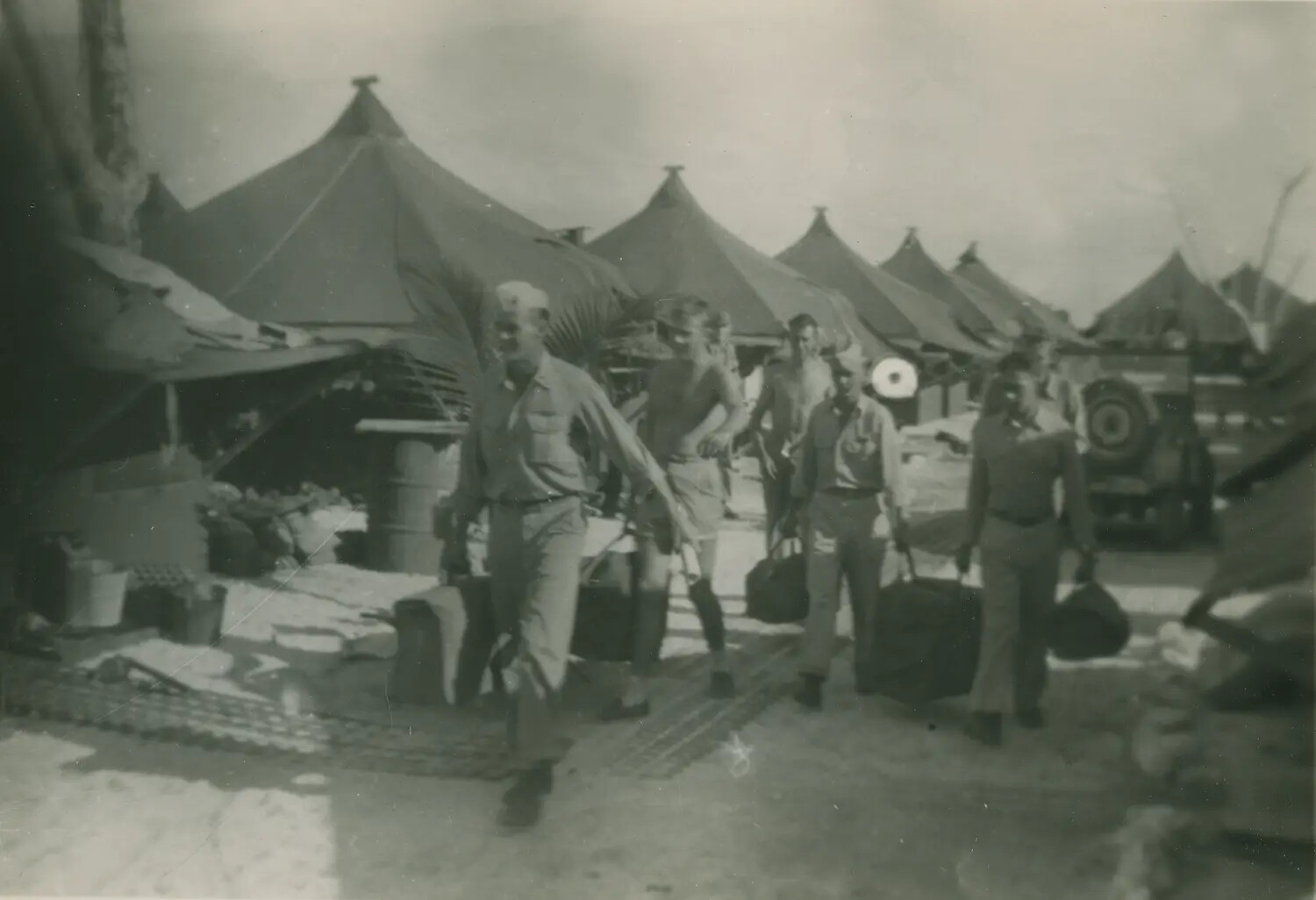 Servicemen Walking Through Tent Encampment with Duffel Bags, Pacific Theater