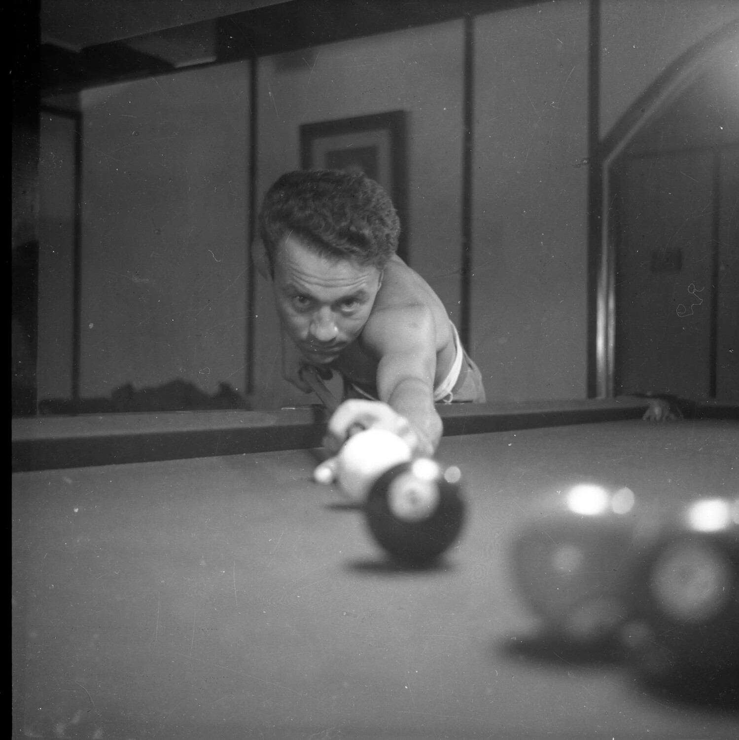 Shirtless Man Lining Up a Shot on a Billiards Table - Recreational Snapshot