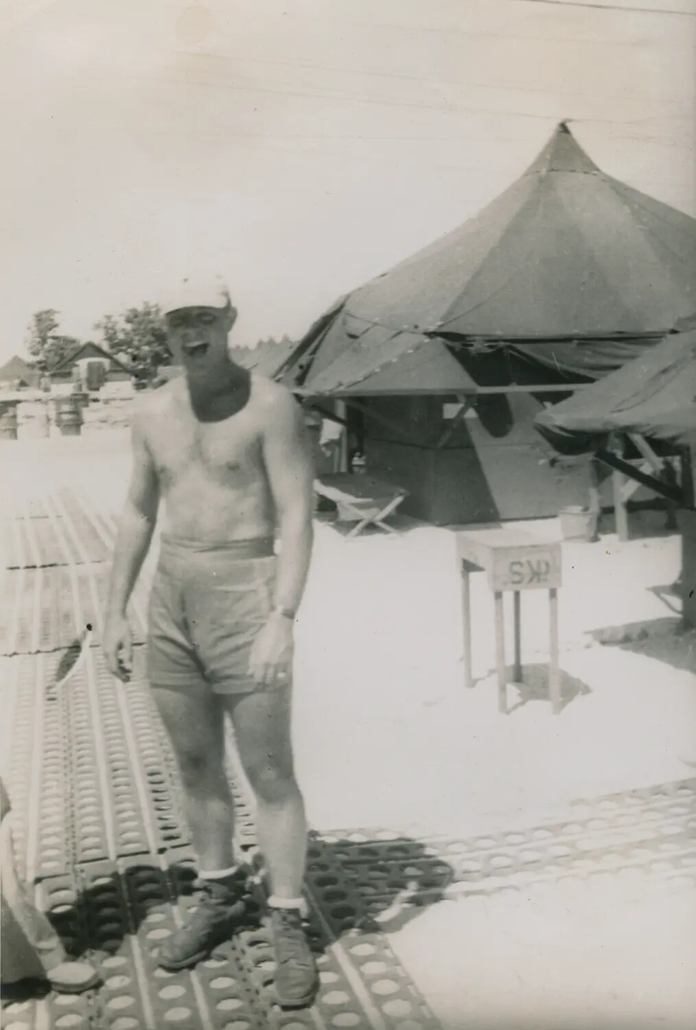 Shirtless Serviceman on Marston Mat Airfield Walkway Near Squad Tent, WWII/Korean War Era
