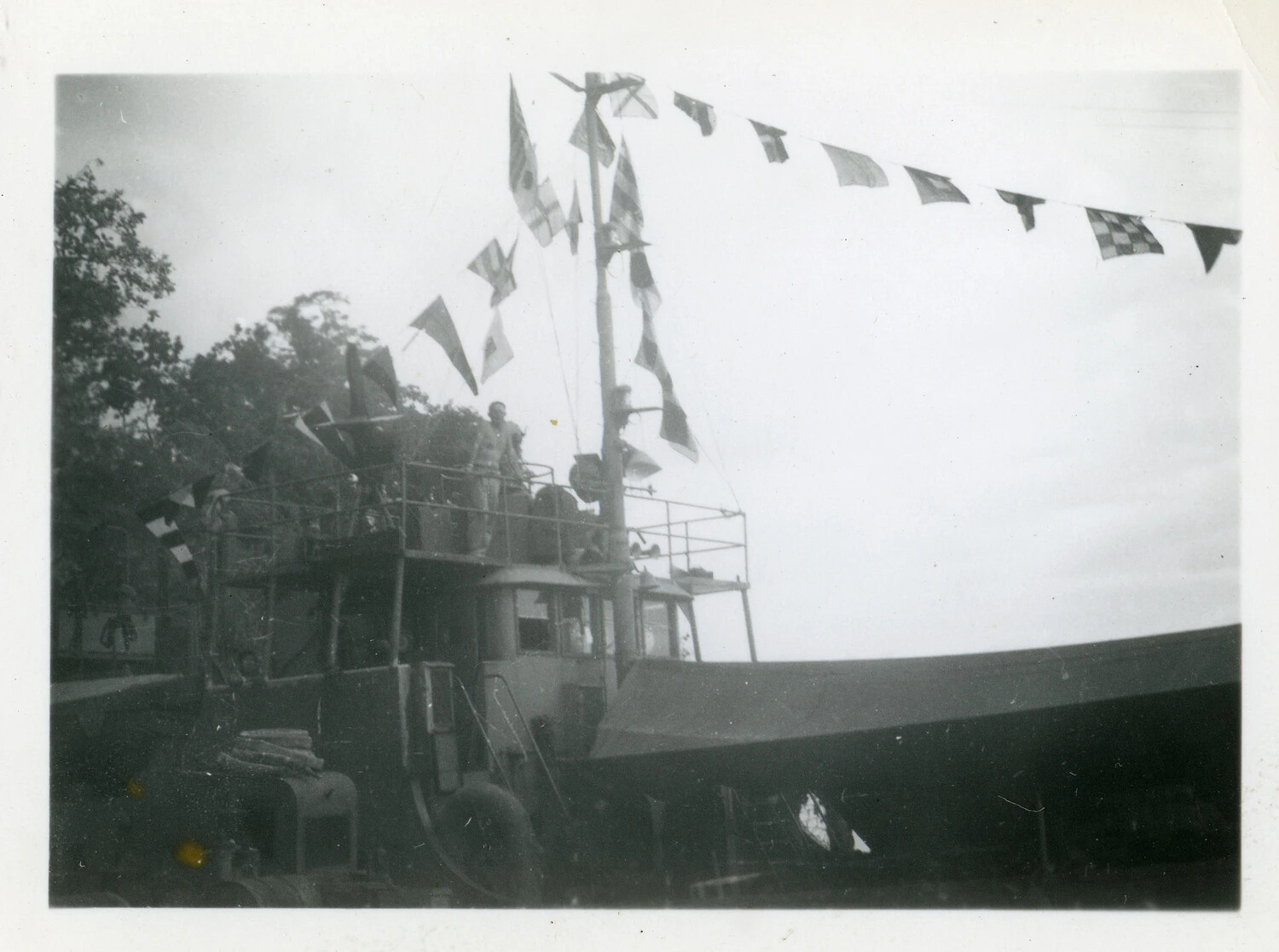 Small U.S. Navy Craft Dressed with Signal Flags in a Pacific Harbor, World War II