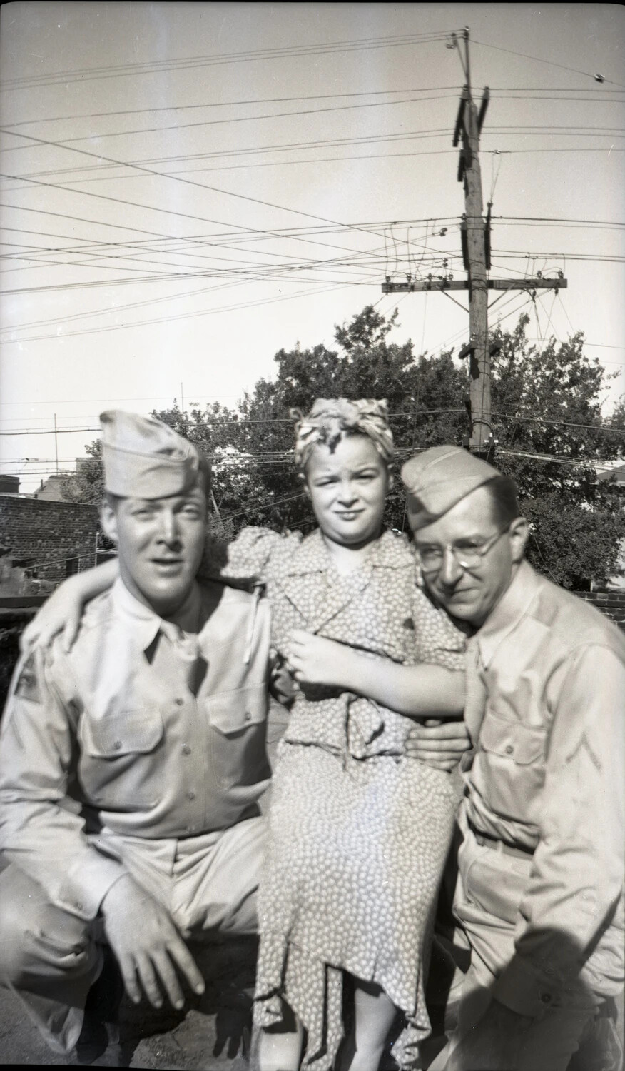 Servicemen Posing with a Young Woman in a Residential Backyard