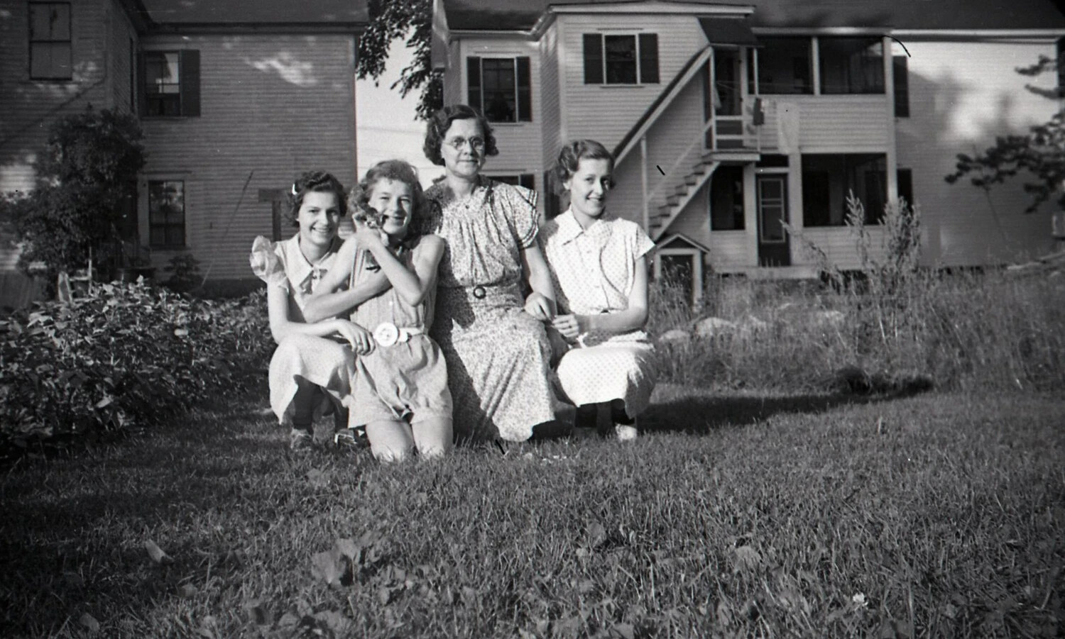 Four Women Posed on a Lawn Before a Triple-Decker Residence, c. 1940s