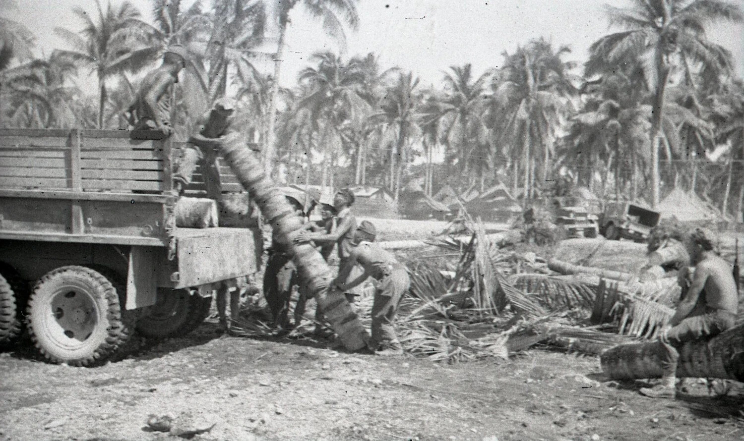 Loading Rolled Bundles onto Army Truck in Coconut Grove, Luzon, Philippines, World War II Era