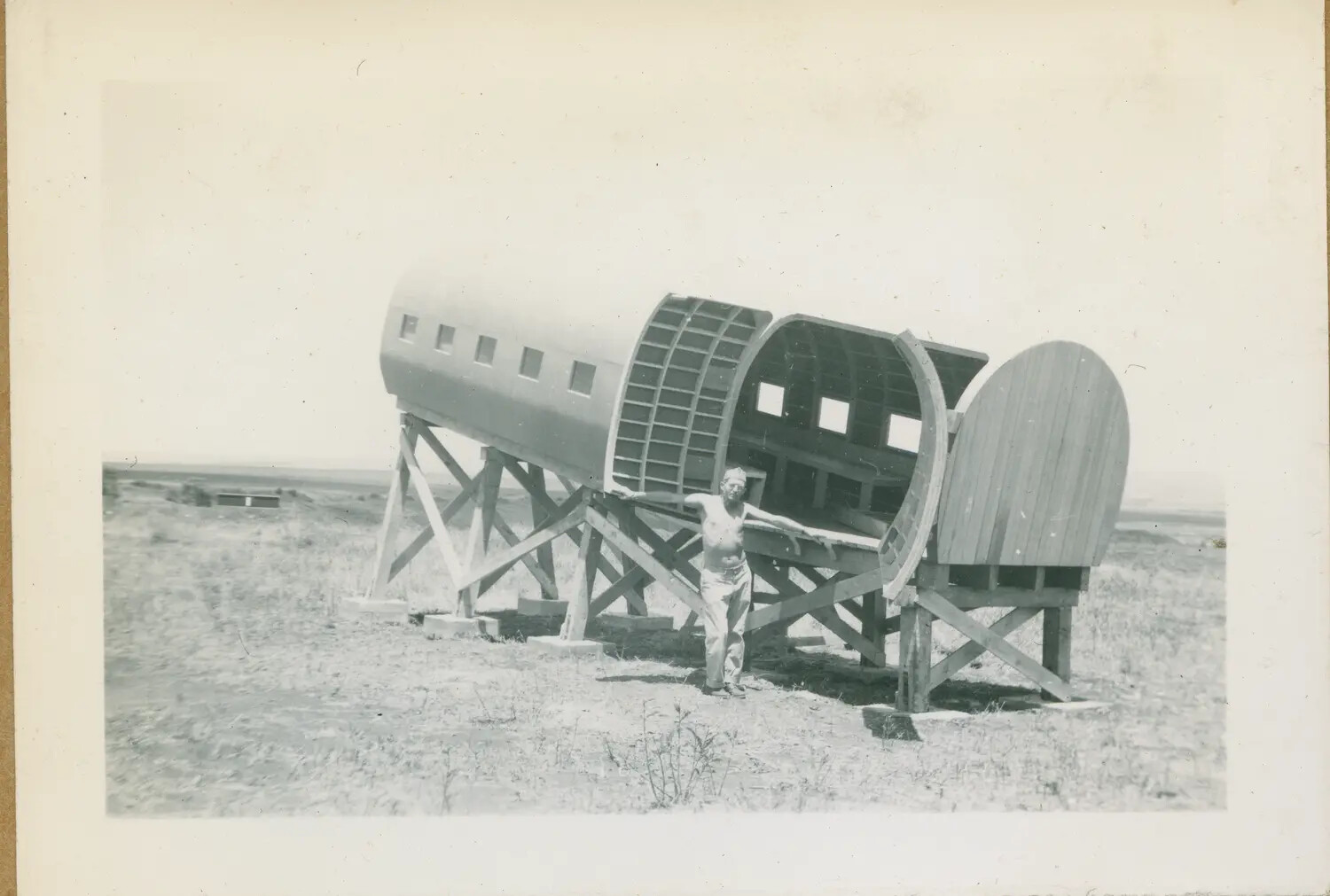 Serviceman Beside Wingless Aircraft Fuselage on Wooden Trestle Stands, Hawaii, WWII