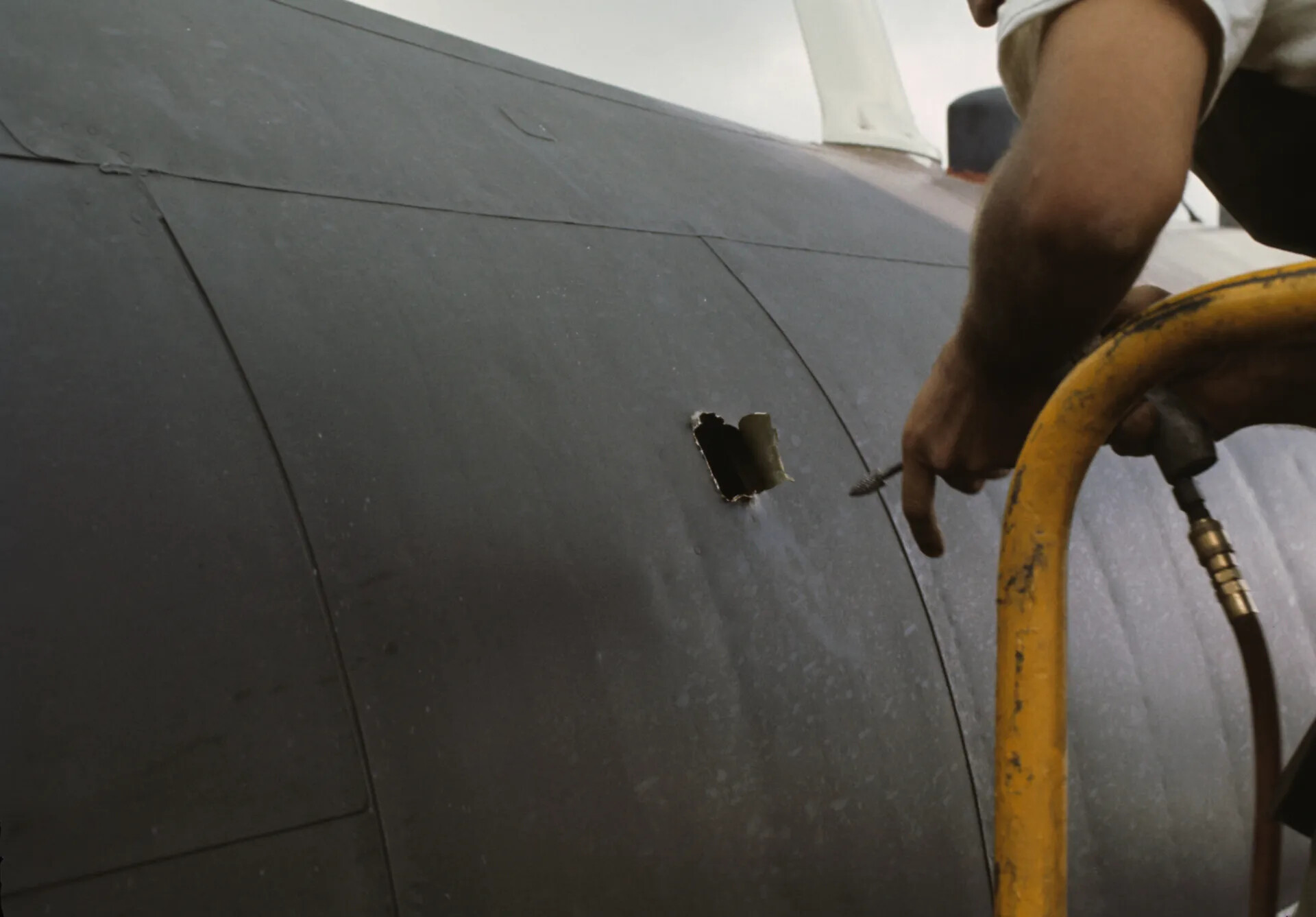 Ground Crewman Repairing Aircraft Skin Damage, Close-Up, November 1969