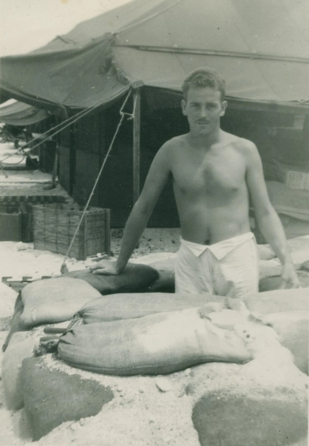 Serviceman Behind Sandbag Emplacement at Military Encampment -- Pat McAleer Photo Album