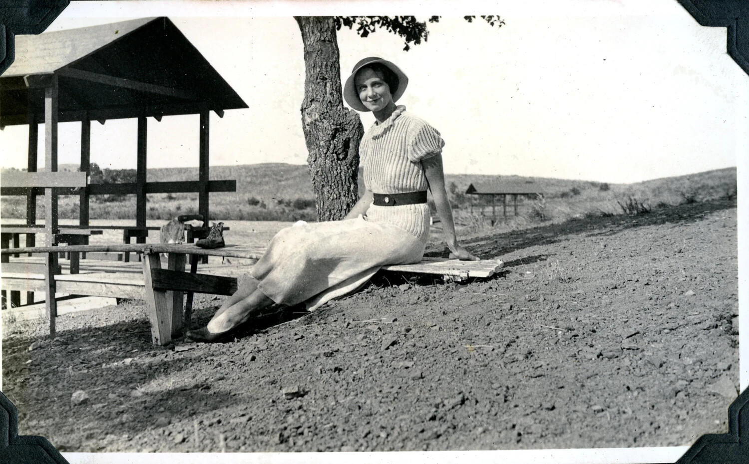 Woman Seated on a Bench Beneath a Tree at a Rural Picnic Ground