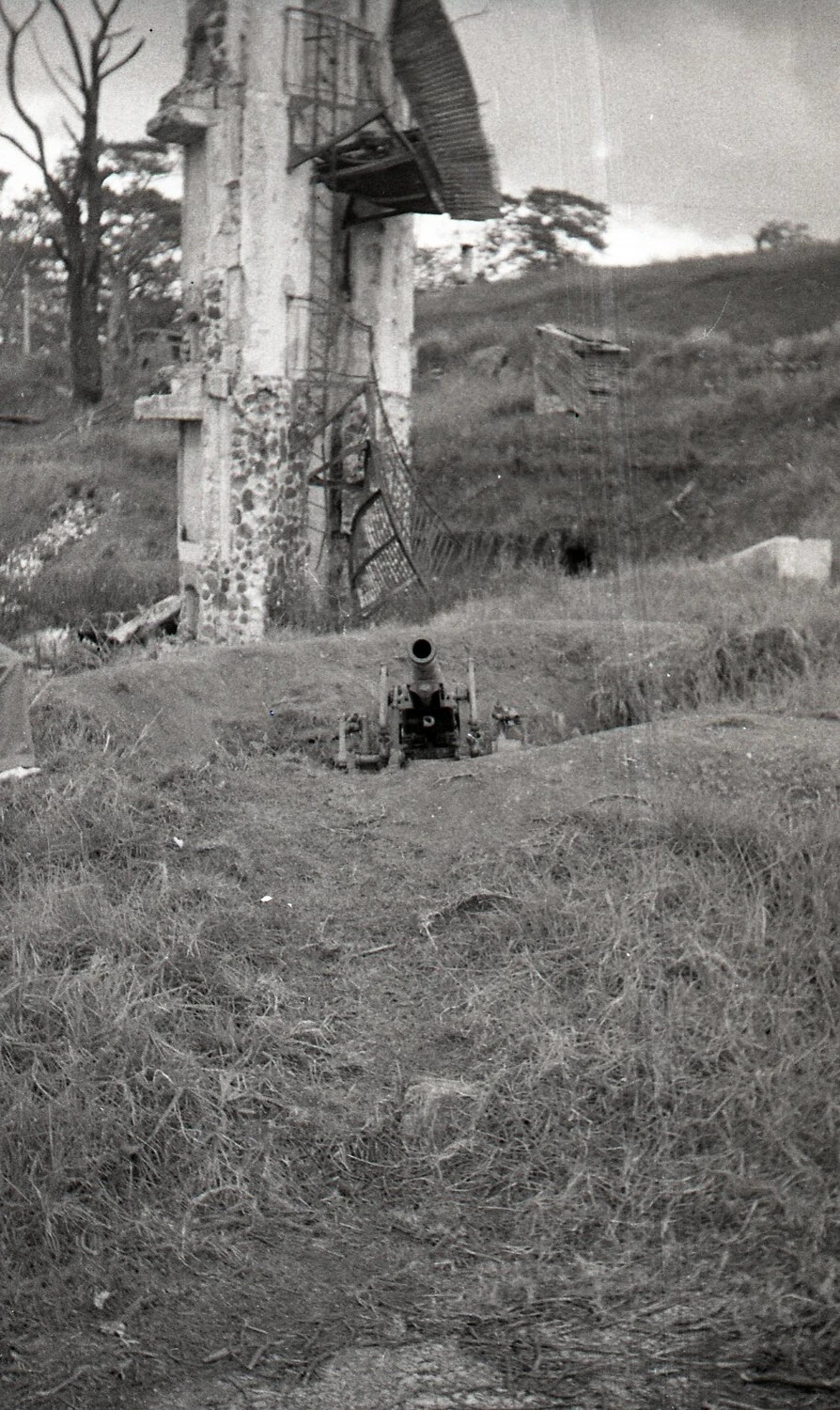 Gun Emplacement Before Battle-Damaged Tower Structure, Luzon, Philippines, WWII