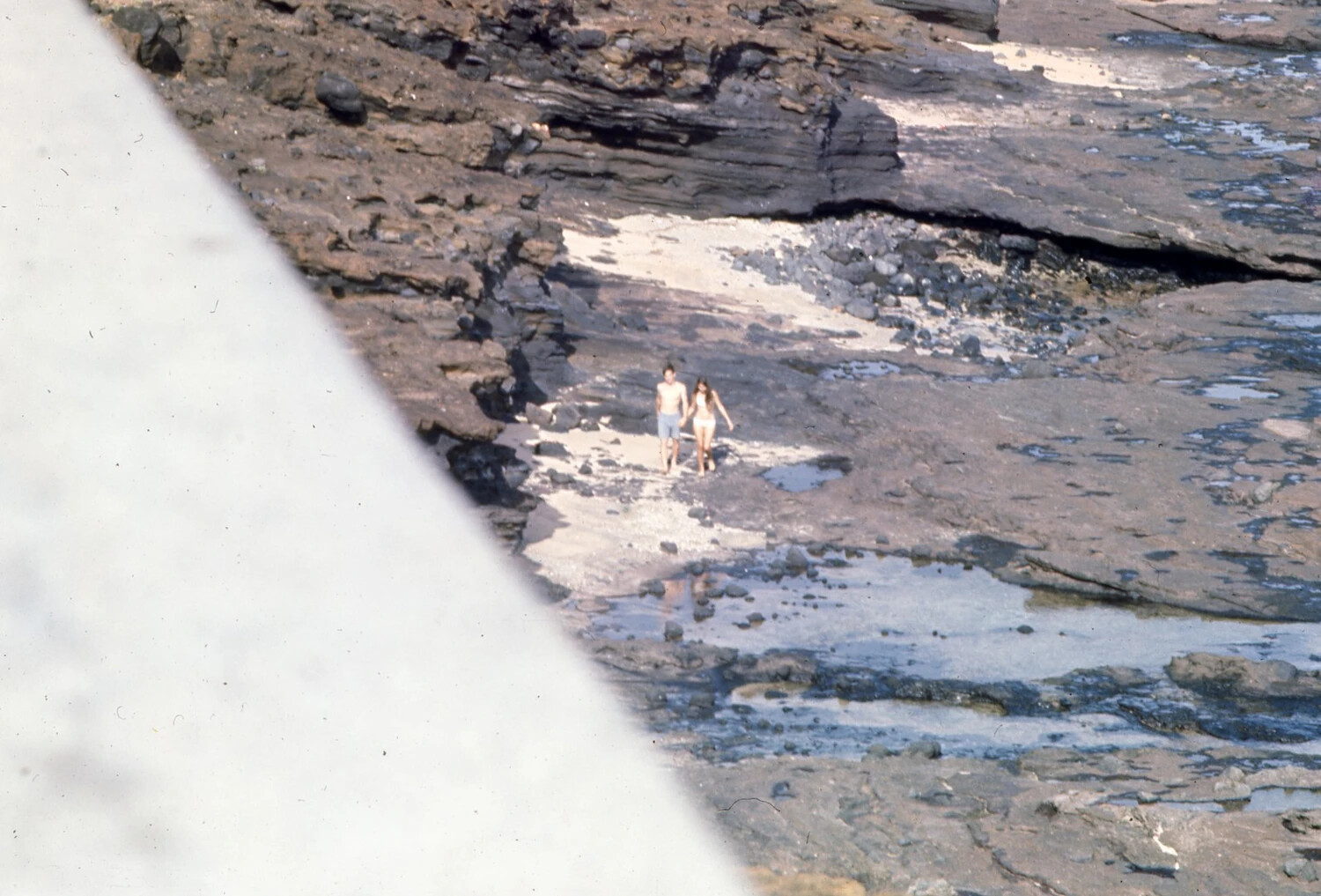 Couple Walking Along Rocky Volcanic Shoreline, Pacific Liberty Port