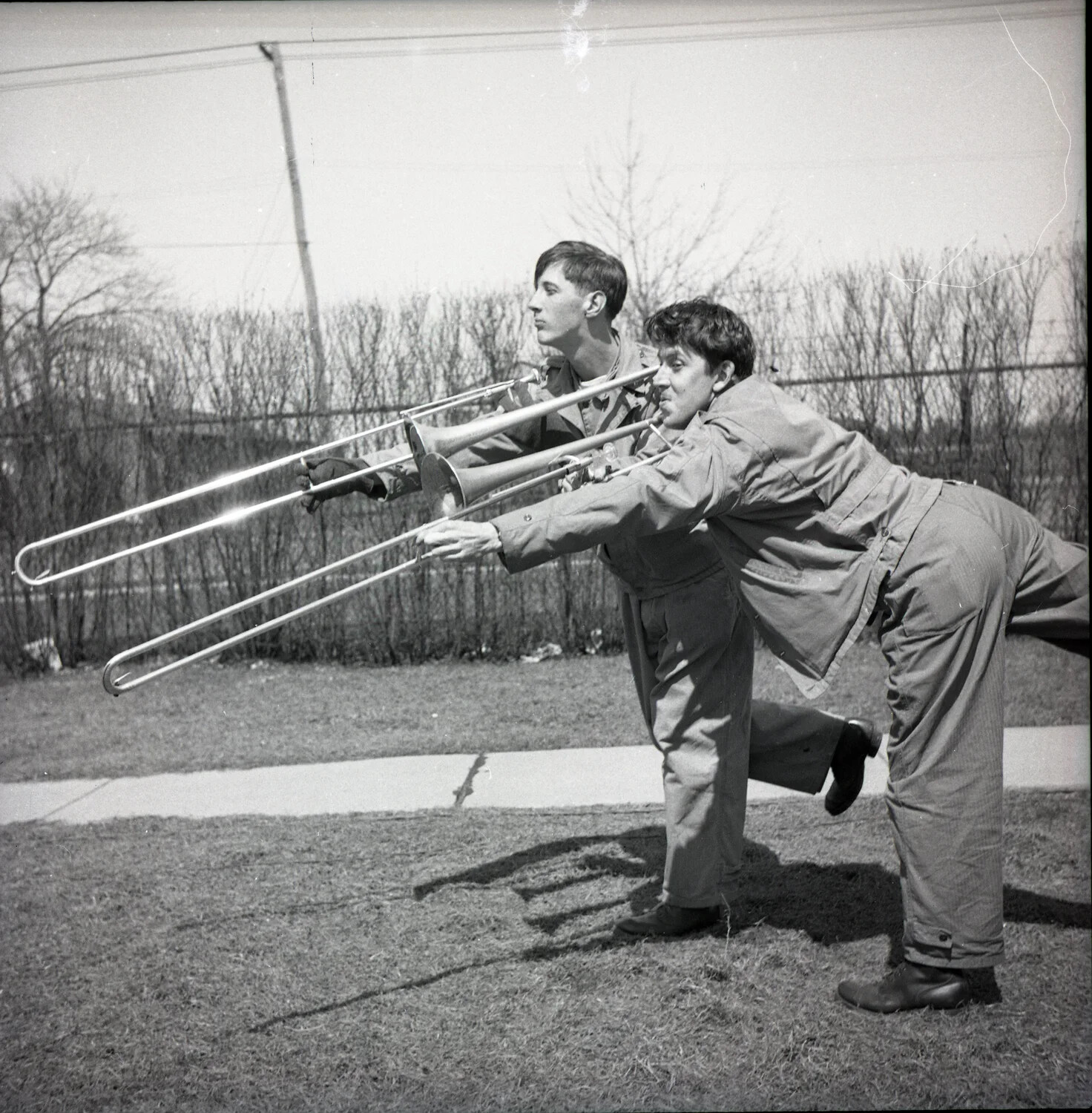 Military Bandsmen Posing in Mock Fencing Duel with Trombones, Outdoor Base Grounds