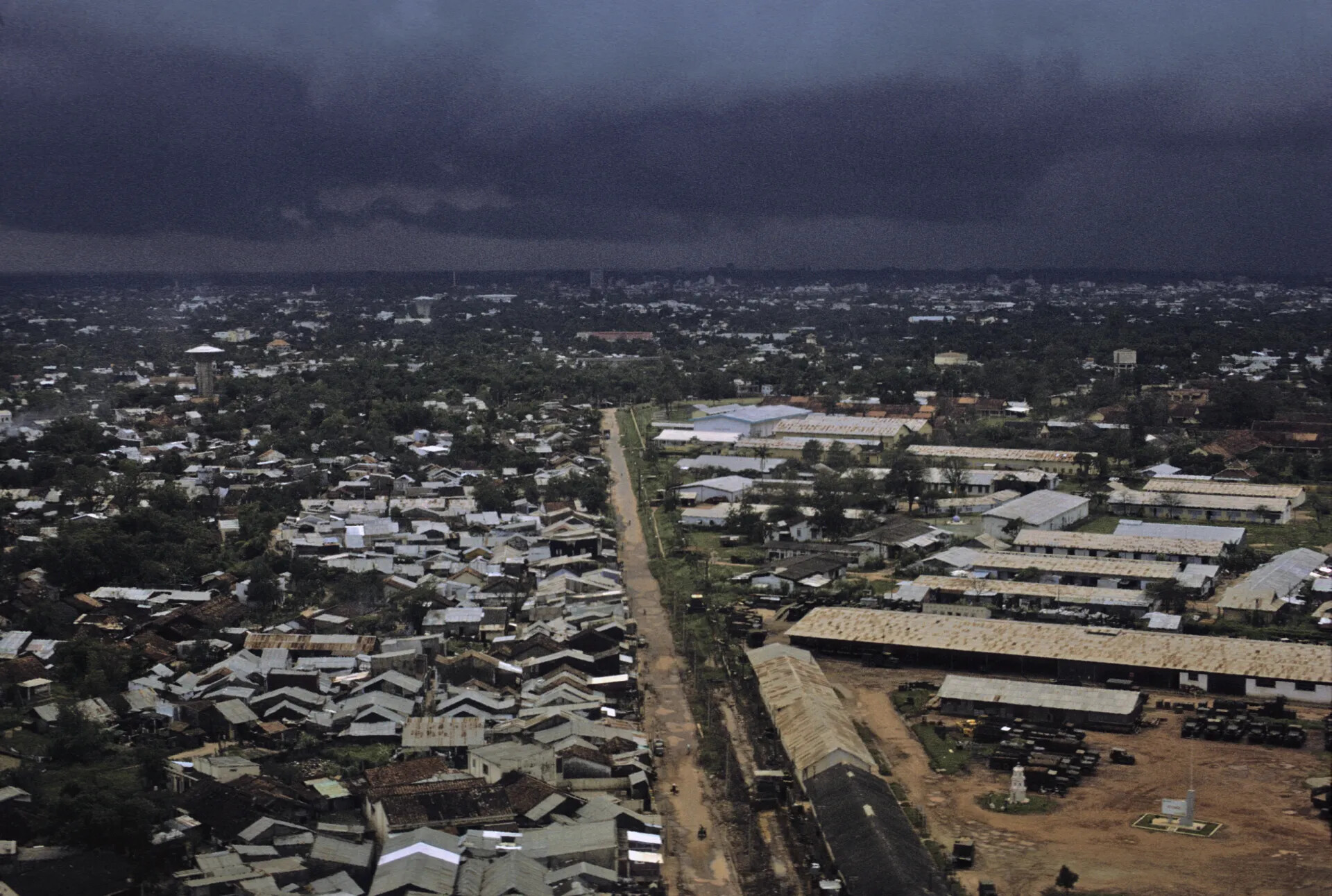 Aerial View of Vietnamese City and Adjacent Military Base Under Storm Front, 1969