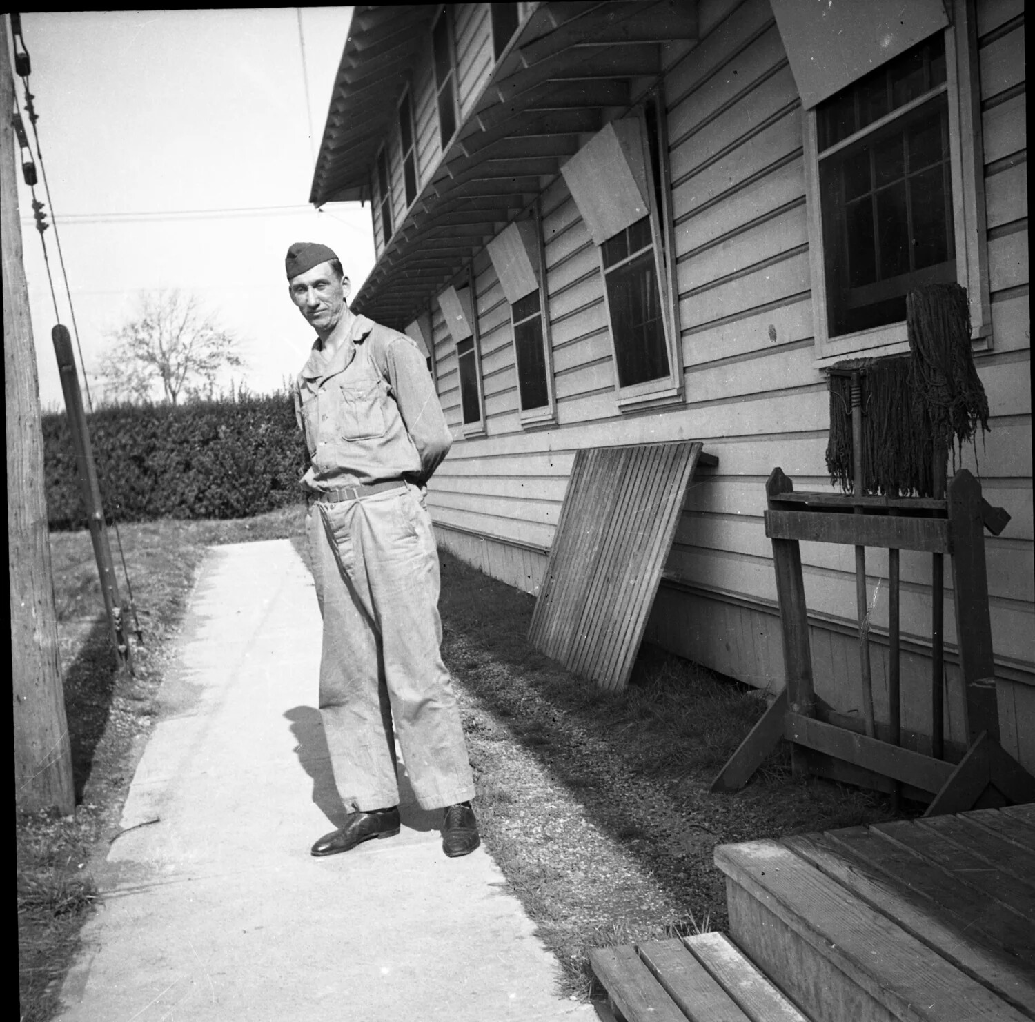 Serviceman in Fatigue Uniform Beside Barracks Building - Base Life Photograph