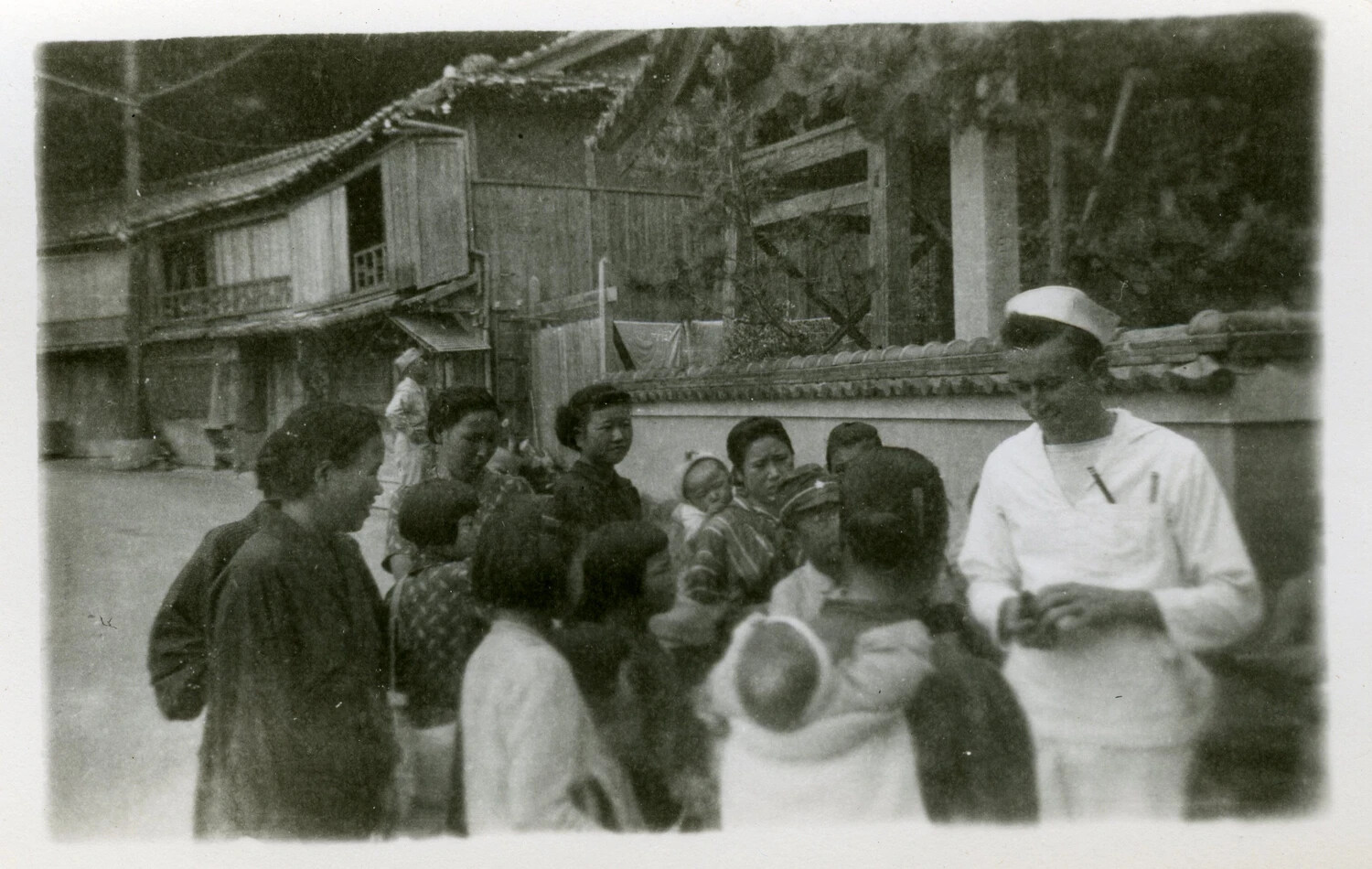 U.S. Navy Sailor with Japanese Civilians on a Village Street
