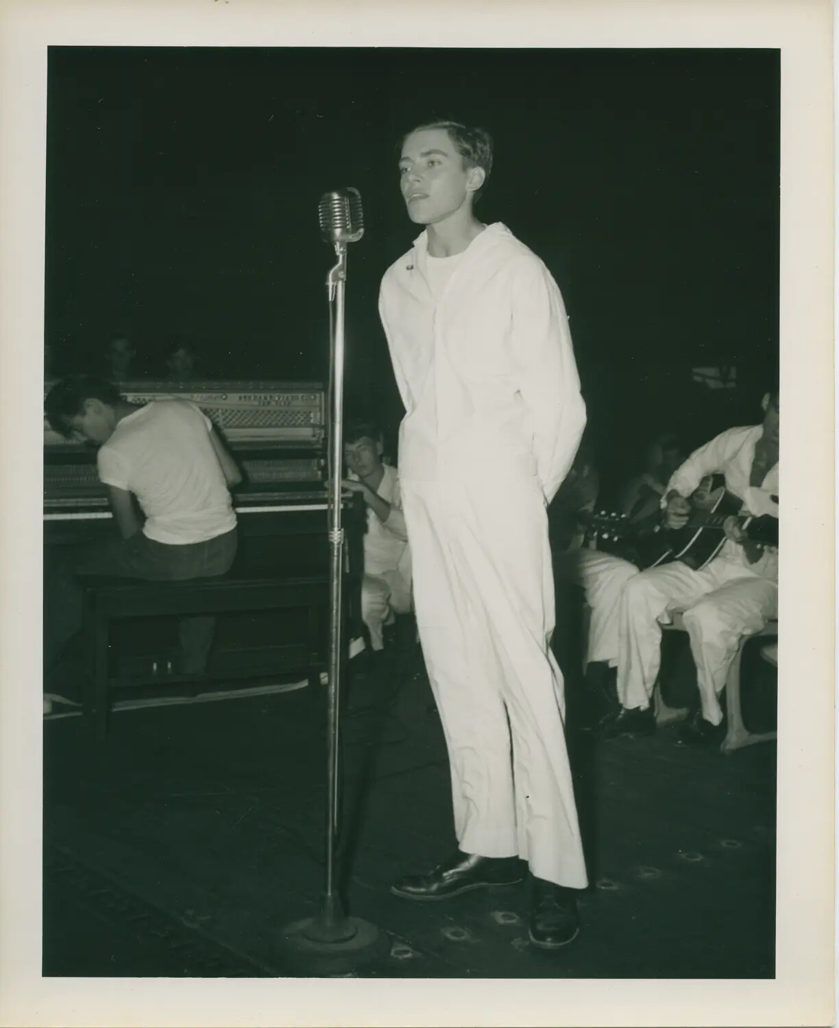 Sailor Singing at Microphone During Shipboard Talent Show, USS Petrof Bay (CVE-80)