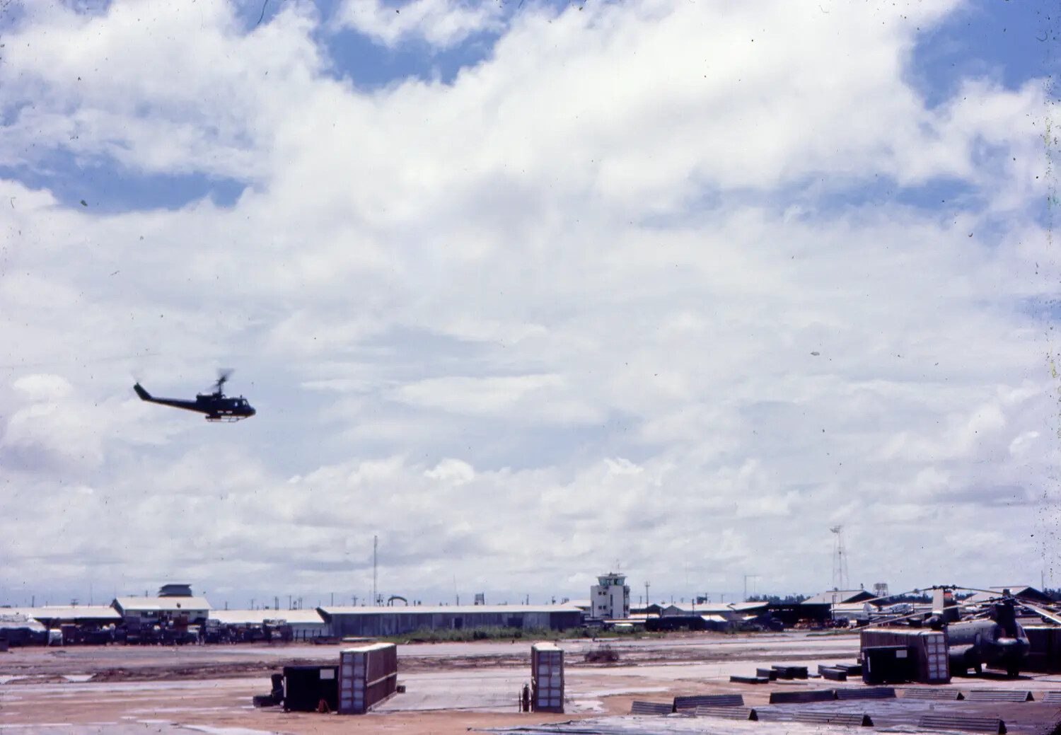UH-1 Huey Helicopter in Flight Over U.S. Air Base, Vietnam War Era