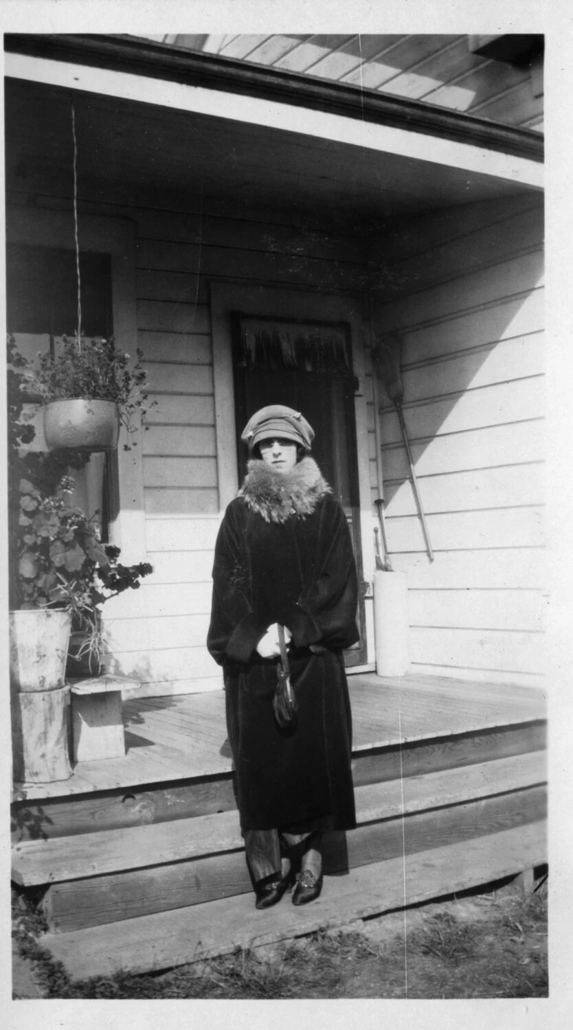 Woman in Fur-Collared Coat and Cloche Hat on Residential Porch, circa 1920s