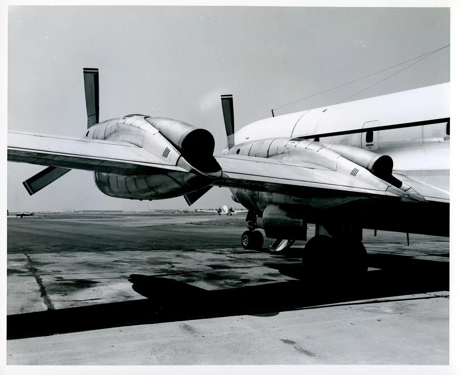 Close-Up of Swept-Wing Jet Aircraft Wingtips and Tip Tanks on Airfield Ramp