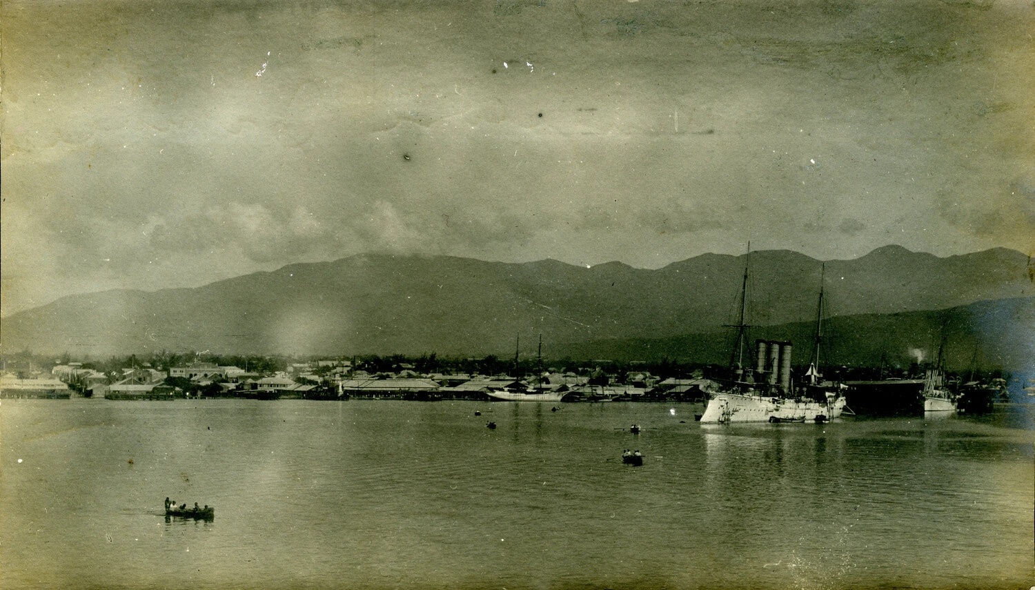 USS Columbia (C-12) Protected Cruiser at Anchor in a Mountain-Ringed Harbor