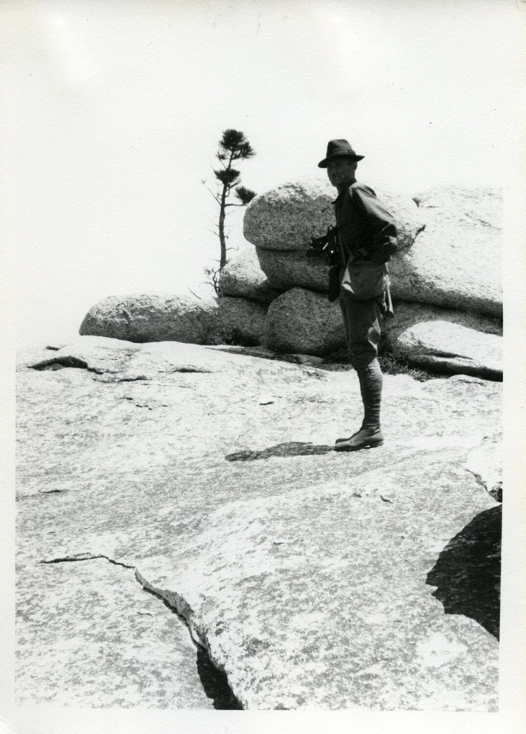 Man in Military-Style Field Dress Standing on Granite Outcrop, Willis Wagener Photo Collection, 1921