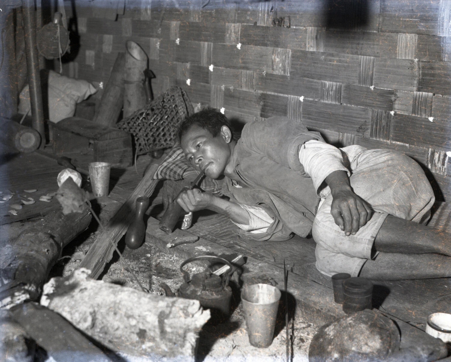 Local Man Reclining with Pipe in Bamboo Dwelling, Burma or China (WWII CBI Theater Collection)