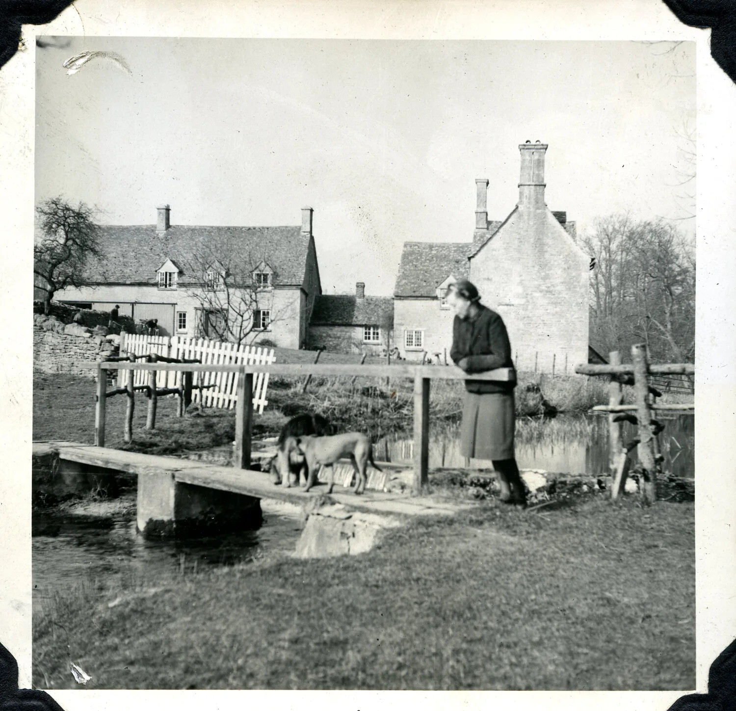 Woman with Dogs on a Footbridge Before English Cotswold-Style Cottages, WWII-Era Personal Photograph