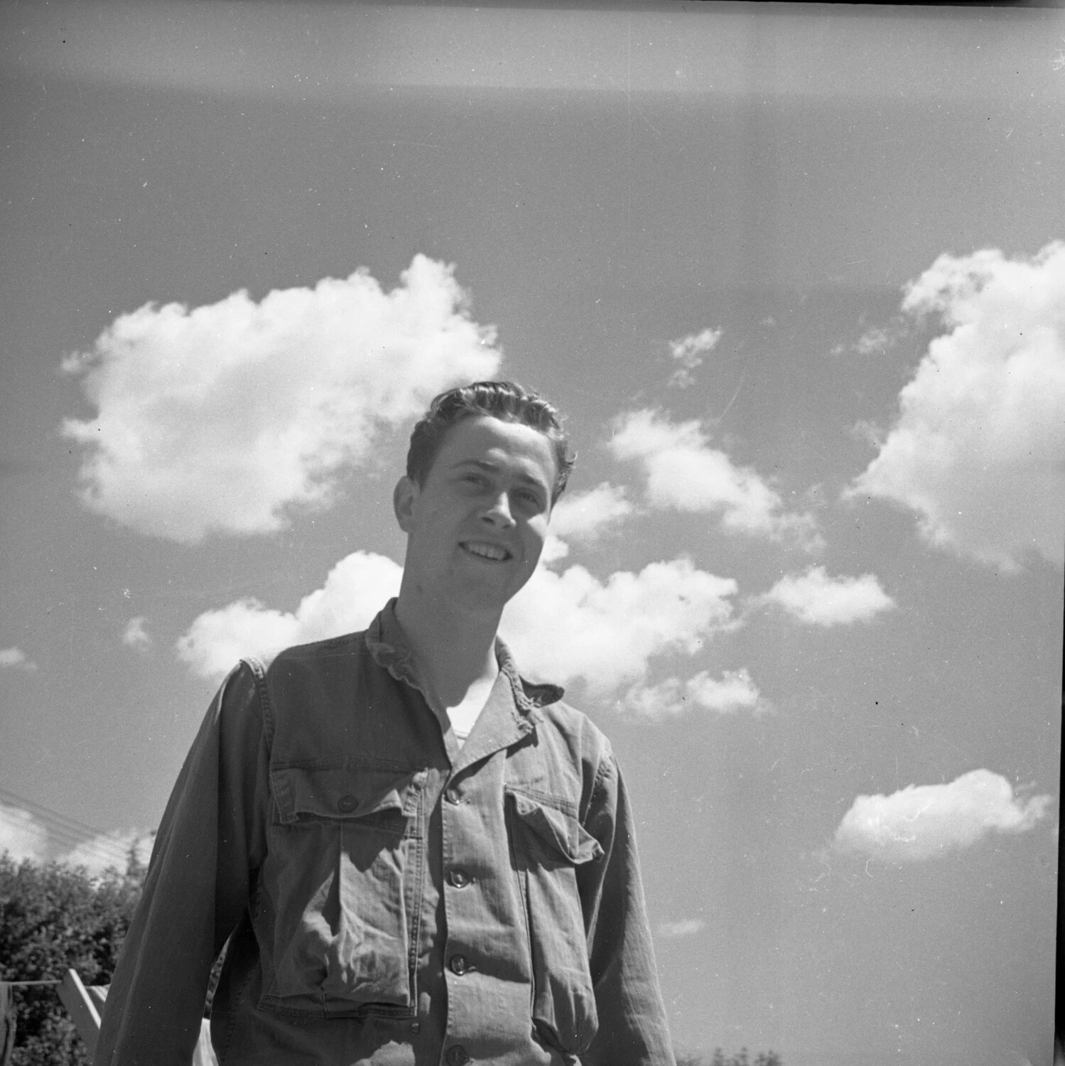 Candid Outdoor Portrait of Young Man Against Cloudy Sky