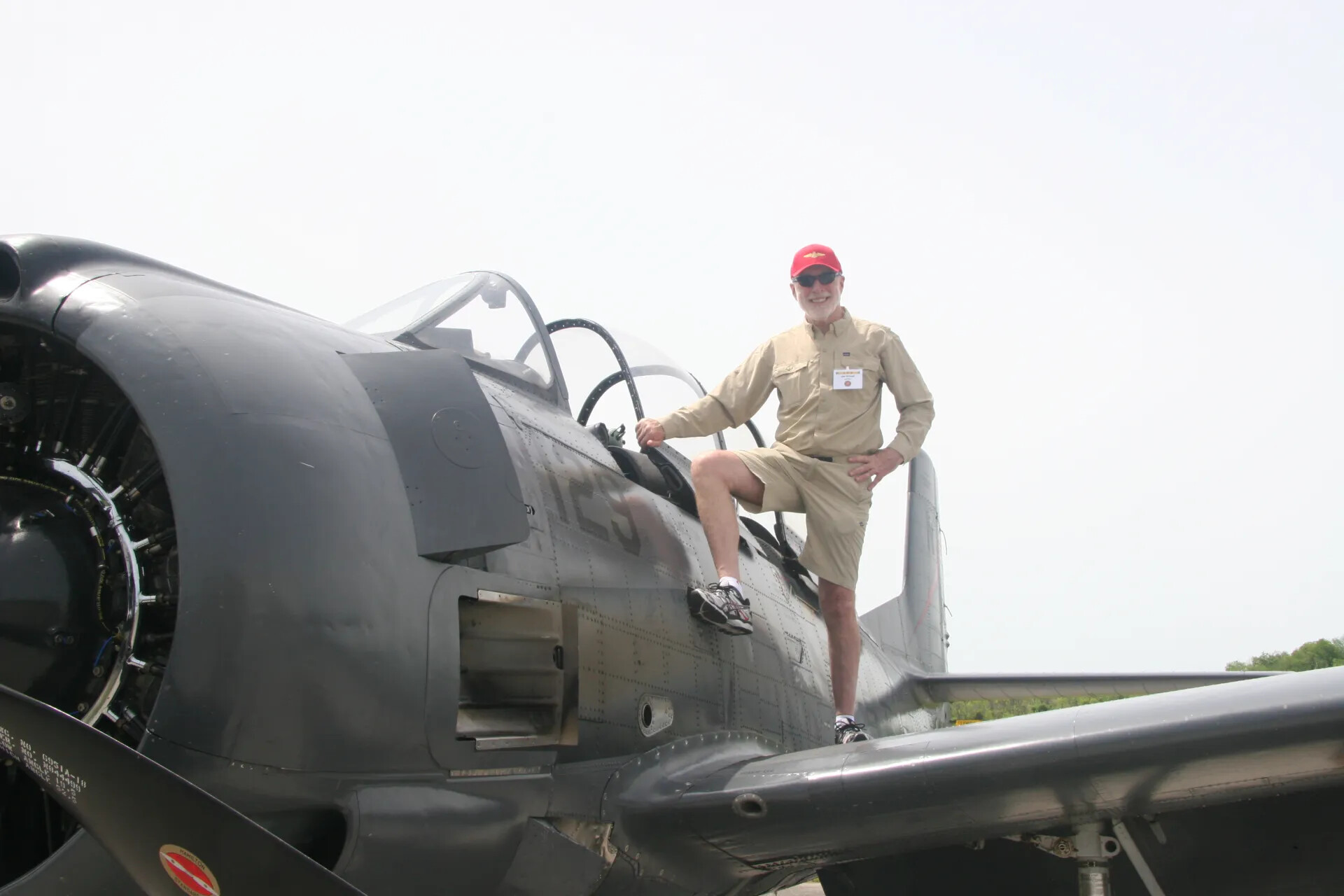 Attendee Posing on Wing of Restored A-1 Skyraider-Type Aircraft