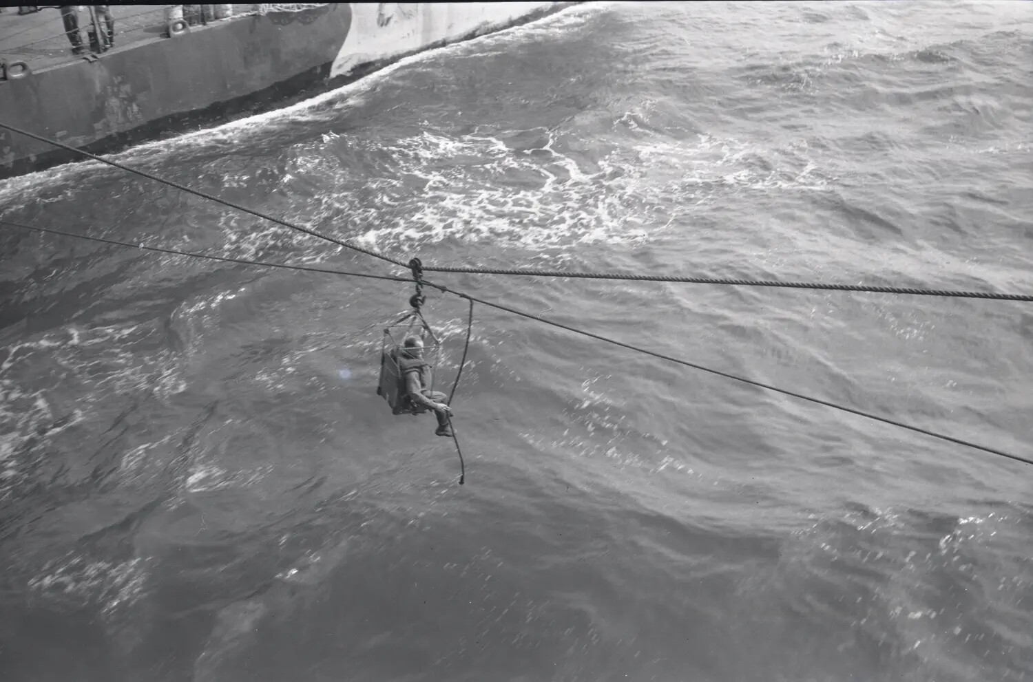 Sailor Transferred via Highline Between Ships Underway, USS Petrof Bay (CVE-80), WWII Era