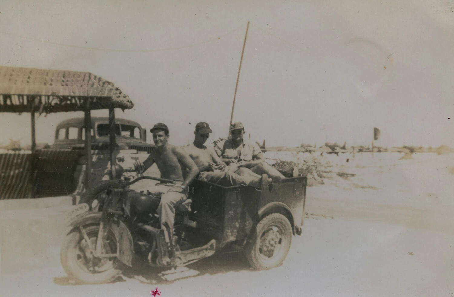 Servicemen Riding a Three-Wheeled Utility Vehicle at a Pacific Airfield, McAleer Collection
