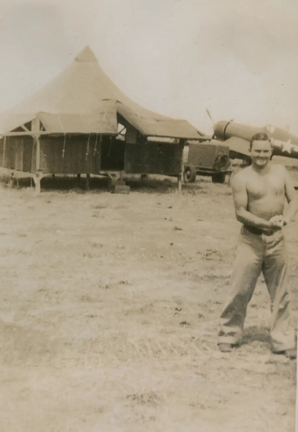 Shirtless Serviceman at Tent Camp with Aircraft and Truck, Pacific Theater, Pat McAleer WWII Collection