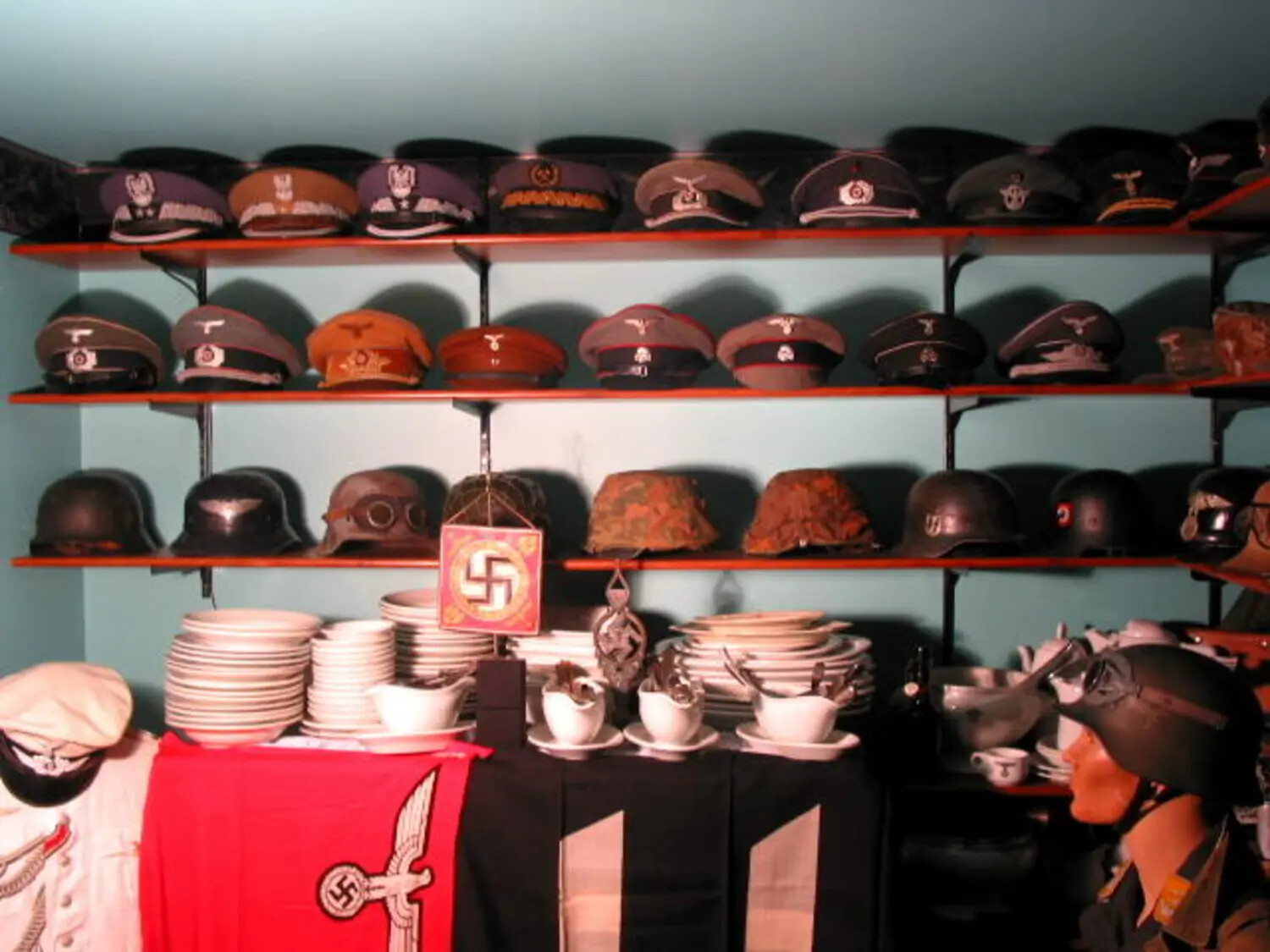 Display of WWII German Militaria: Visor Caps, Helmets, and Period Artifacts