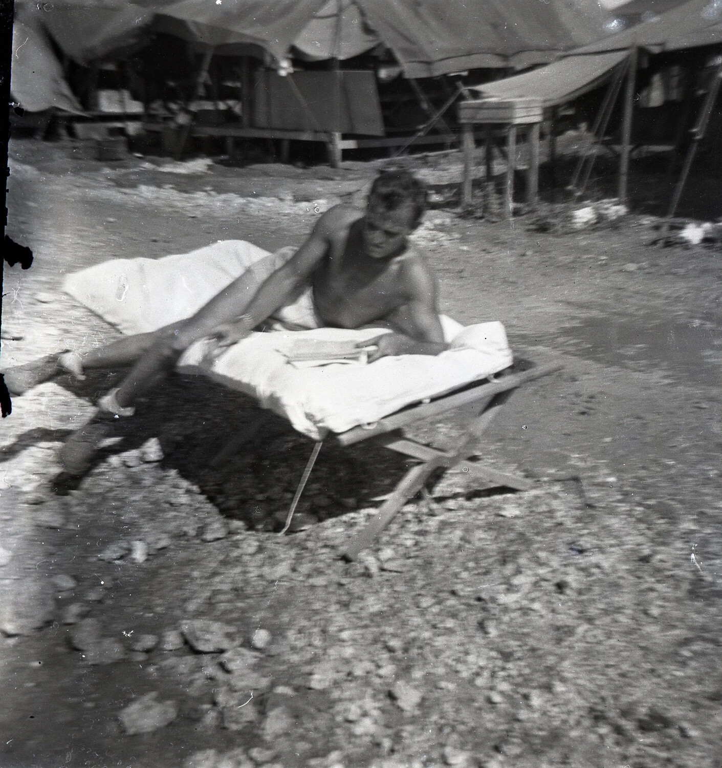 Serviceman Reading on Folding Cot in Camp Area — 345th Bombardment Group Encampment, Ie Shima, WWII